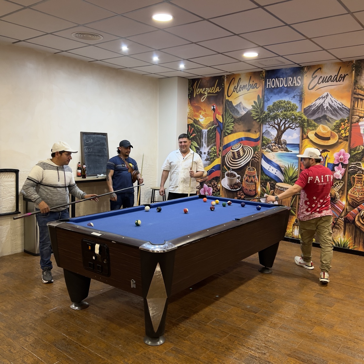 Sala de billar de Alcurnia Latina, con el mural de Venezuela, Colombia, Honduras y Ecuador